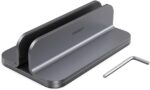 Spacegrey aluminum vertical laptop stand holding a MacBook Pro, showcasing its sleek design and desktop organization.