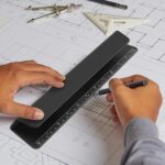 Black Psitek portable laptop cooling stand, made of aluminum, shown elevating a laptop on a desk surface.