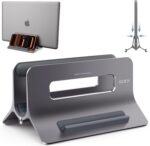 A space gray SODI vertical laptop stand holding a MacBook in an upright position on a clean desk.