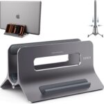 A space gray SODI vertical laptop stand holding a MacBook in an upright position on a clean desk.
