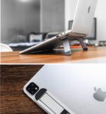 Space Grey Triyards self-adhesive foldable laptop stand attached to the underside of a laptop, elevating it.